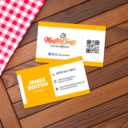 Restaurant branding business cards for MasterChefs displayed on wooden table with checkered cloth