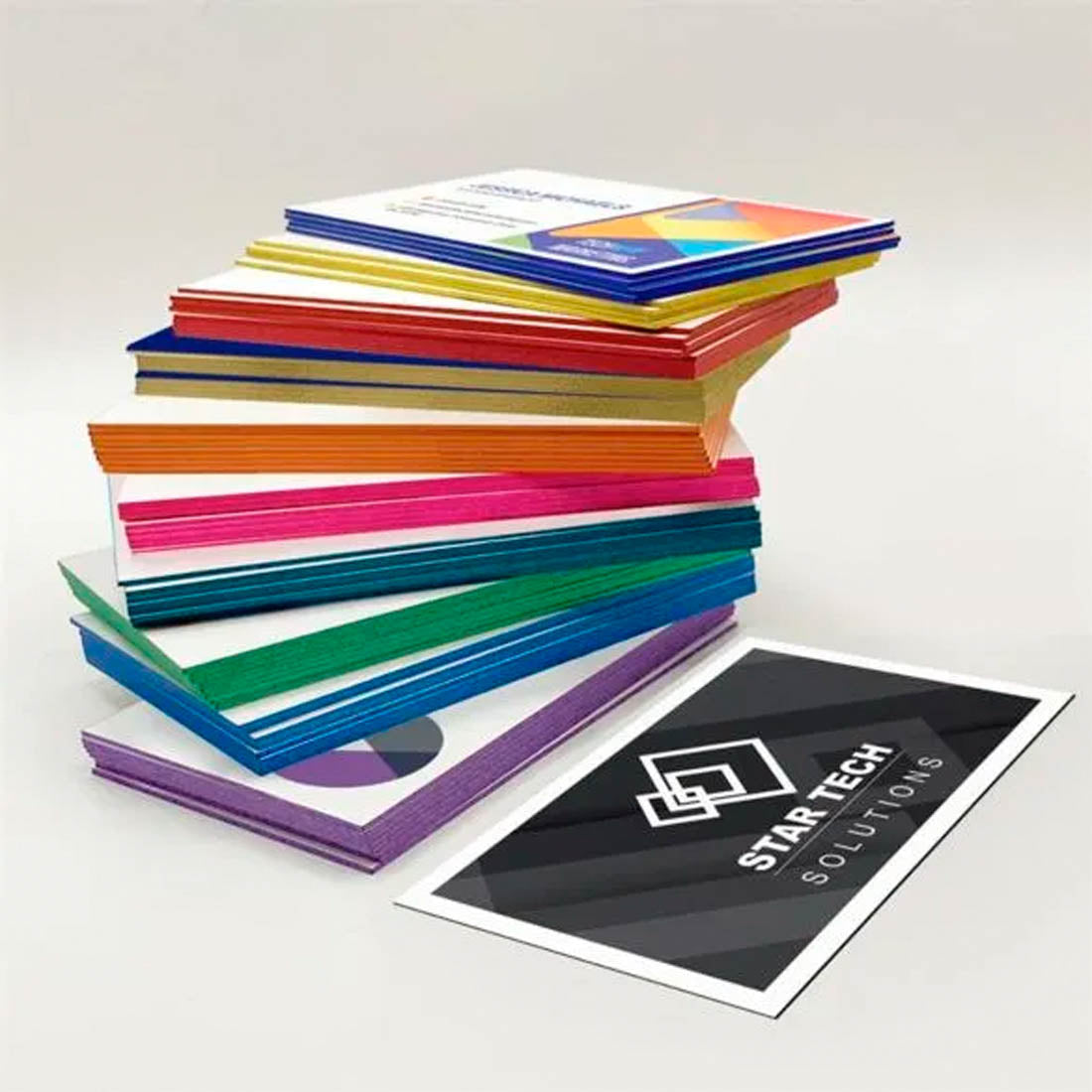 Stack of thick business cards with colorful painted edges and premium print designs