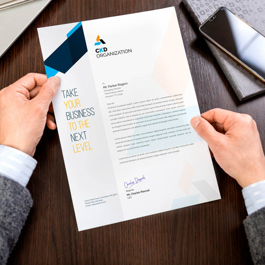 Professional letterhead design with geometric branding elements on desktop workspace