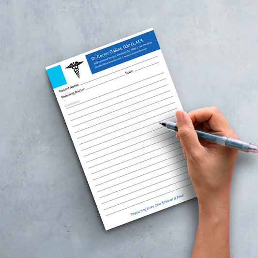 Doctor writing on medical referral pad