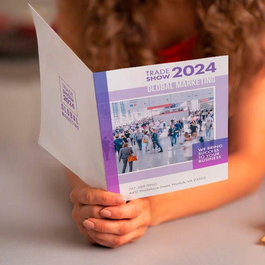 Folded trade show brochure with business marketing design held in hands